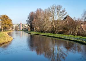 De gerestaureerde boerderij Langeveld langs de Ringsloot. Op de achtergrond de Ooievaarstraat. (Foto: Jan van der Voet, 2022.)