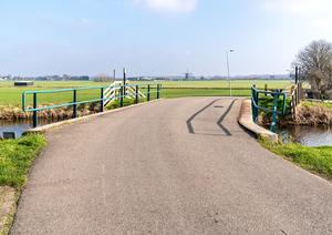 Een actuele foto van de brug over de 3e Poellaan. In de verte staat de Lisserpoelmolen. Let op het hoogteverschil! (Foto: Jan van der Voet, 2023.)