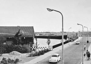 De Ruishornlaan is in gebruik. De belangrijkste verbinding tussen de Poelpolder en het dorp is open. Links de kistenfabriek ELKA en daarachter de Greveling. (Fotograaf onbekend, 1970.)