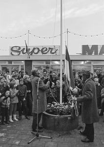 Oud-burgemeester De Graaf hijst de vlag in het zojuist geopende noodwinkelcentrum. (Noord-Hollands Archief, collectie Fotopersbureau De Boer, 1968.)