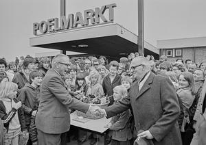 Burgemeester Berends opent winkelcentrum Poelmarkt. Dat deed hij door met een knop de neonverlichting boven de ingang aan te zetten. De Poelmarkt verving het noodwinkelcentrum. (Noord-Hollands Archief, collectie Fotopersbureau De Boer, 1974.)