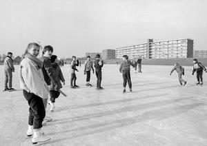 Jeugd op de ijsbaan. Achter de slaperdijk staan de flats van het Rembrandtplein. (Noord-Hollands Archief, collectie Fotopersbureau De Boer, 1985.)