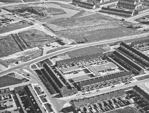 Luchtfoto van het noodwinkelcentrum. De noodwinkels lagen op het binnenterrein tussen Ooievaarstraat, Sperwerstraat, Nachtegaalstraat en Uitermeer. (Fotograaf onbekend, 1968.)
